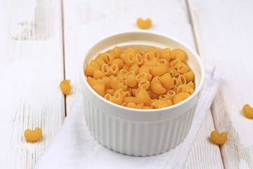 Raw dry pasta on a white wooden background