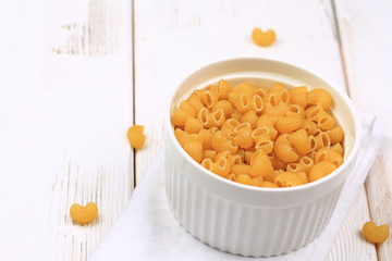 Raw dry pasta on a white wooden background