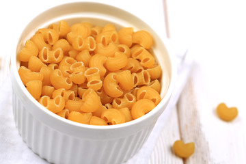 Raw dry pasta on a white wooden background