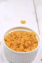 Raw dry pasta on a white wooden background