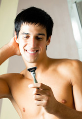 Shaving man at bathroom