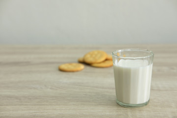 A GLASS OF MILK
A glass of milk with pile of crackers on the wood top table. 