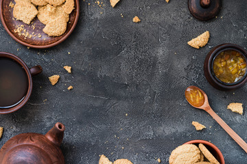 Obraz na płótnie Canvas Cookies, orange jam, tea on dark background, copy space. Dessert concept