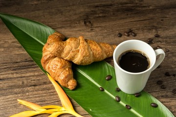 coffee break, White coffee cup, croissants on wood table background, selective focus. Breakfast concept