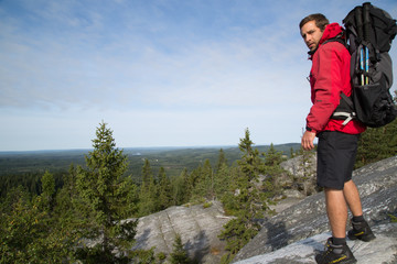Fototapeta premium Hiker stands on the summit from Akka-Koli and enjoys the natural landscape, summer 