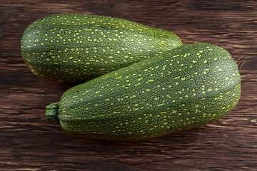 Raw Freshly picked organic marrow zucchini vegetables with leaves on wooden table