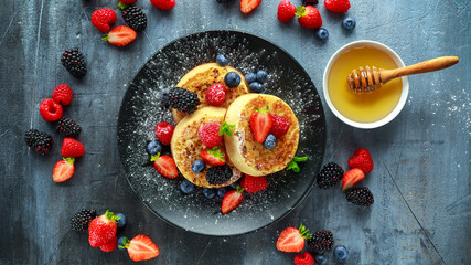 British Crumpets breakfast with blueberries, strawberries, blackberries, raspberries drizzled with...