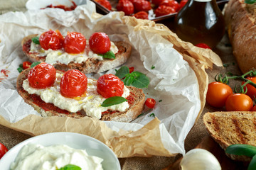 Tomato Ricotta Bruschetta with sun dried tomatoes paste, olive oil brown bread and basil