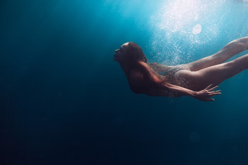 Fototapeta na wymiar Young woman swimming in sea. Underwater view