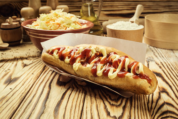 Barbecue Grilled Hot Dog with sauce,Hot Dog With Yellow Mustard,Onion,Pickles and French Fries,Tasty hot-dogs with vegetables on wooden background, close up,hot dogs with mustard, ketchup and relish