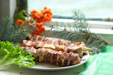 Pork shish kebab with fir branches, rowan and green leaf of lettuce cooked on the grill for Christmas dinner for the designer