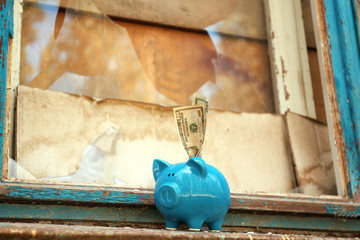 Old window and piggy bank with money. Window repair concept