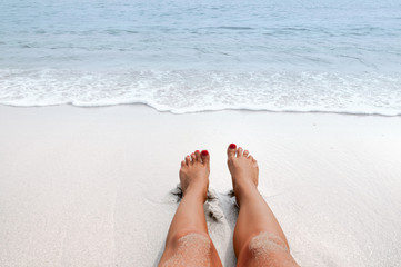 Vacation on the beach, feet on seashore