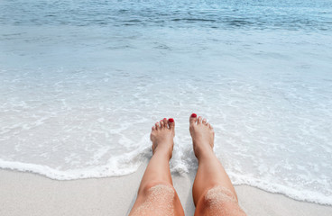 Vacation on the beach, feet on seashore