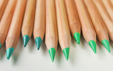 Pencils of green shades on white background