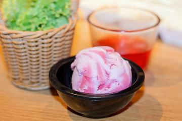 strawberry sherbet homemade icecream on the wooden table with sunshine background.