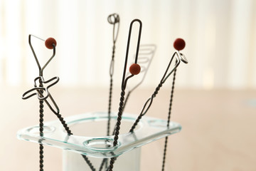 Stand with set of logopedic probes for speech correction on light background, closeup