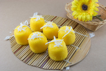 Palm cake with flower on wood table background.