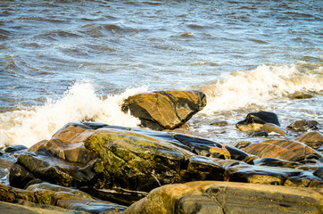 rocks at coastline with splashing wave