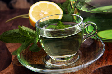 Cup of mint tea and leaves of mint on the table