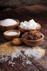 Various types of sugar, brown sugar and white on wooden table