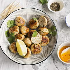 Homemade chicken meatballs with a spicy sour sweet sauce in a plate on the table. Top View.