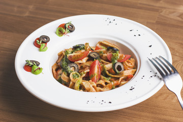 Homemade tomato pasta with olives and pesto
