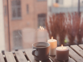 White cup of coffee or tea near a candles