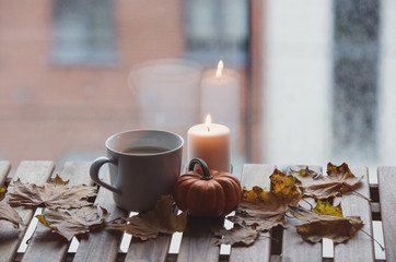 Obraz na płótnie Canvas White cup of coffee or tea near a pumpkin and candle