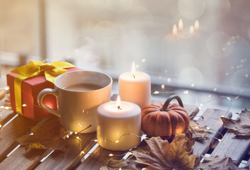 cup of coffee or tea near a pumpkin and candles