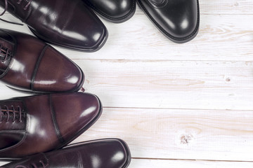 Male fashion with shoes on wooden background.