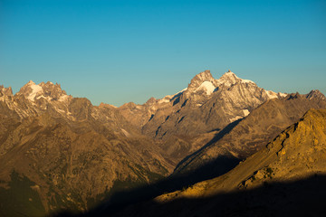 The majestic peaks of the Massif des Ecrins (4101 m) national park with the glaciers, in France. Telephoto view from distant at sunrise. Clear sky, autumn colors.