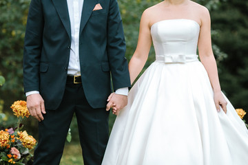 fashion, event, occasion concept. ravishing couple of young lovers dressed in wedding suits, shapely bride is in the marvelous dress of classical style, fiance is wearing elegant costume