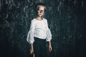 Portrait of a serious pensive schoolgirl in big glasses. Educational concept.