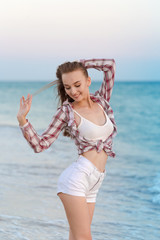 Happy carefree woman on the beach enjoying summer