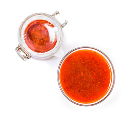 Fortified jam from fresh berries of sea buckthorn mashed with sugar in a glass jar and a vase with jam 