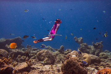 Little girl diving in a coral reef