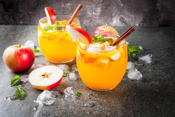 Traditional fall drinks, Apple cider mojito cocktails with mint, cinnamon and ice. On black stone...