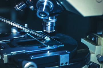 scientific microscope lens. observing a pipette with a suspension. dripping on a preparative glass