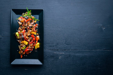 Grilled vegetables with spices on a plate. On a wooden background. Top view. Free space.