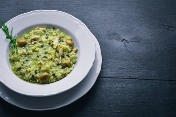 Risotto with spinach, cheese and olives. On a wooden background. Top view. Free space.