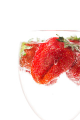 ripe juicy red strawberry in a glass with water