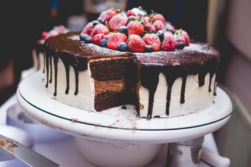 Chocolate ganache and vanilla buttercream cake with strawberries, blueberries, and raspberries