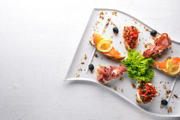 Bruschetta Sandwich with salmon and hamoon. On a wooden background. Top view. Free space.
