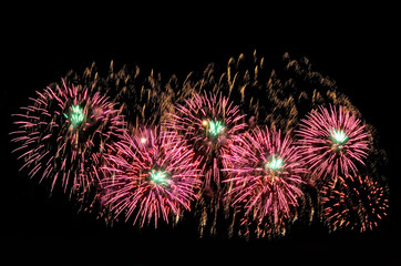 Pink and green fireworks and scattering of gold sparks