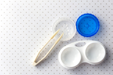 Accessories for working with contact lenses: container and tweezers. View from above.