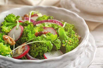 Dish with broccoli salad on table, closeup