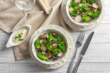 Dishes with broccoli salad on table