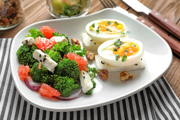 Plate with broccoli salad on table