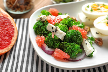 Plate with broccoli salad on table